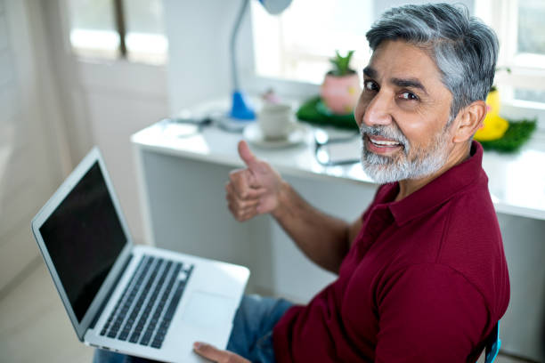istock Businessman using laptop and giving thumbs up gesture 1298766174