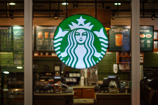 Starbucks cafe interior - empty cafeteria behind glass wall with company logo sign, Moscow, 27.09.2019