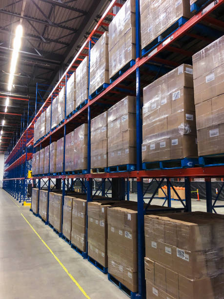 Cases of wine stacked on pallets in distribution center. Many cases of wine stacked on pallets in distribution center. wine shipping stock pictures, royalty-free photos & images