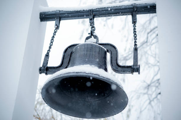 an iron bell covered with frost and snow on a frosty day on the top of Mount Belorie next to the Belogorsk monastery. Ural, Russia.