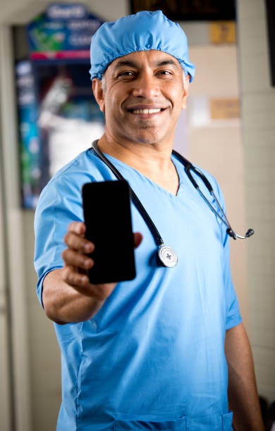 istock Male surgeon showing mobile phone 1298780037