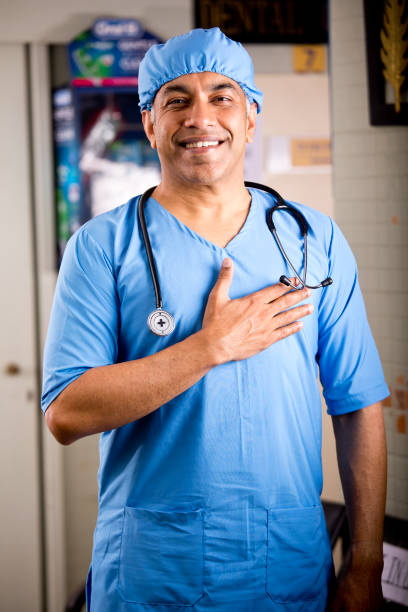 happy male surgeon with hand on chest - nurse doctor scrubs male imagens e fotografias de stock