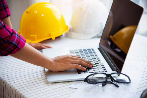istock Workers and manager in safety helmets working with documents at factory .Engineer Concept 1298782097