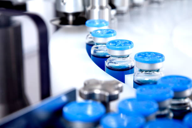 Botol kaca dalam produksi di nampan dispenser cair otomatis, garis untuk mengisi obat-obatan melawan bakteri dan virus, antibiotik dan vaksin