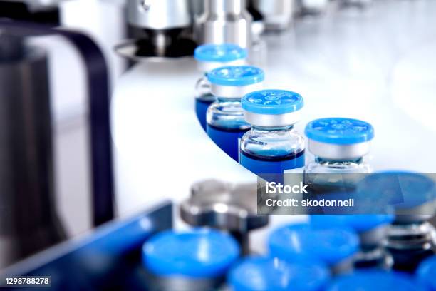 Glass Bottles In Production In The Tray Of An Automatic Liquid Dispenser A Line For Filling Medicines Against Bacteria And Viruses Antibiotics And Vaccines Stock Photo - Download Image Now