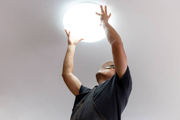 istock Electrician with white helmet checking lighting to the ceiling in the home, technician concept. 1298795072