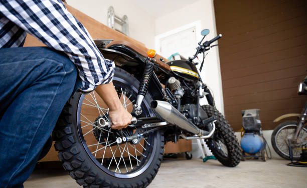 istock Young man fixing motorcycle, Mechanical hobby and repairs concept. 1298795075