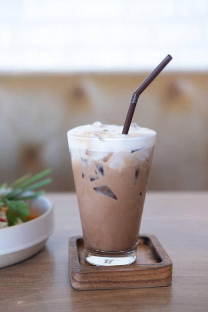 istock Iced Mocha coffee in glass on wood table at cafe. 1298796038