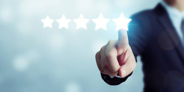 Businessman pointing five star symbol to increase rating of company Businessman pointing five star symbol to increase rating of company adulation stock pictures, royalty-free photos & images