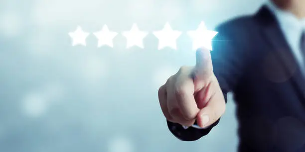 Photo of Businessman pointing five star symbol to increase rating of company