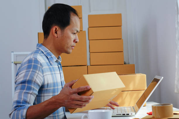 istock Asian men using laptop for delivery goods. 1298809346