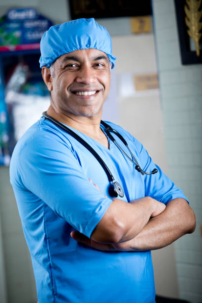 istock Happy male surgeon with arms crossed 1298809496