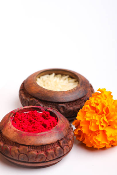 istock Rice Grains, Kumkum and marigold flower on white background 1298810035