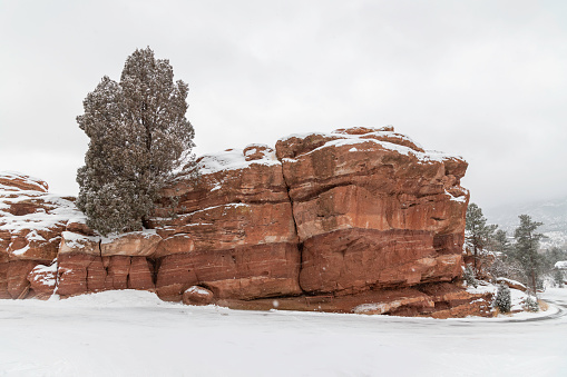 Massive and tall sandstone formation of park in Colorado Springs, Colorado during winter snow fall.