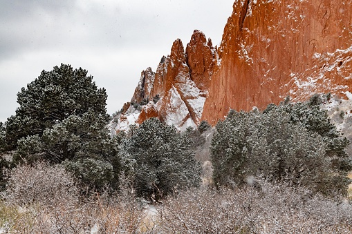 Massive and tall sandstone formation of park in Colorado Springs, Colorado during winter snow fall.