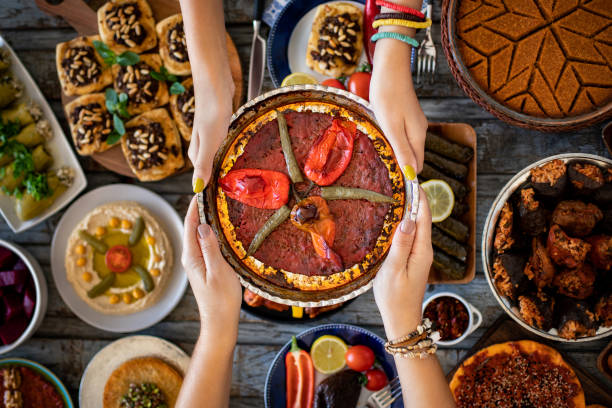 muitos tipos de comida e meze na mesa de jantar. comidas locais chamadas sini kebabı e tepsiye et basma. - halal beef - fotografias e filmes do acervo