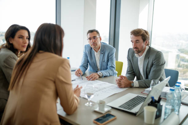 istock Businessmen sitting at the conference table with their female colleagues, analyzing data 1298824098
