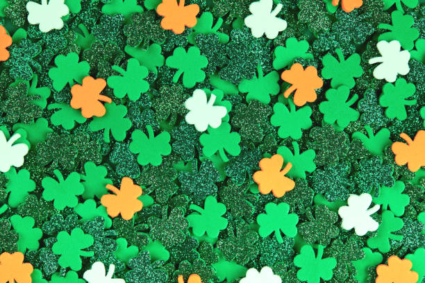 istock Shamrock confetti texture background with green orange and white lucky clovers 1298824625