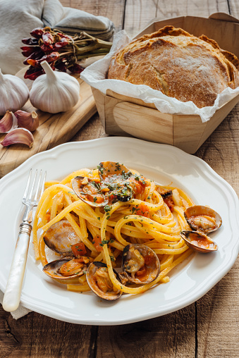 Fresh bigoli with seafood with tomato sauce, clams and mussels.