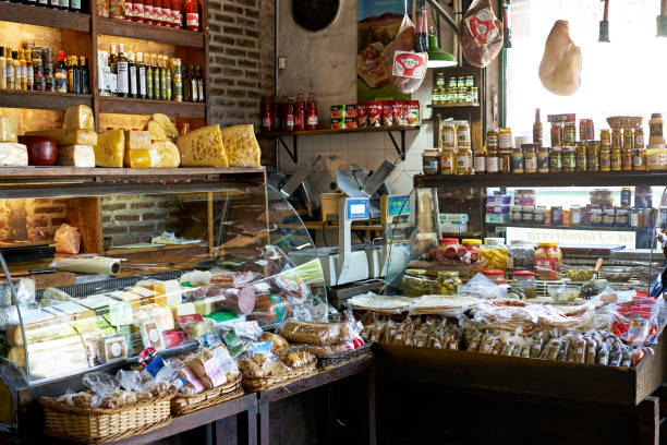 Gourmet Merchandise in Argentine Specialty Store Retail display cases, shelves, and baskets filled with cheeses, meats, breads, spices, and other foods for sale in unoccupied small shop. display cabinet photos stock pictures, royalty-free photos & images