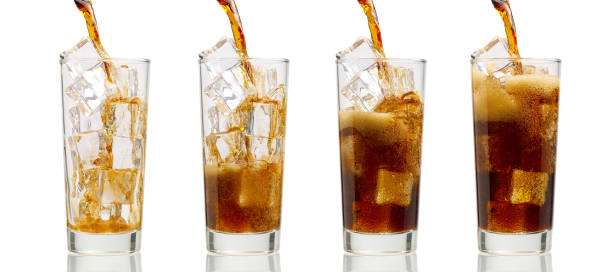 istock Pouring Cola to glass with ice cubes isolated on white 1298832481