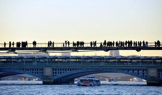 London, December 29, 2016, Westminster, Millennium Bridge: Many passers-by are on the bridge in winter. The winter of 2016 with sunshine and temperatures of around 10 degrees was ideal for a stroll through town. In the background, the Modern Tate can be seen against the light.