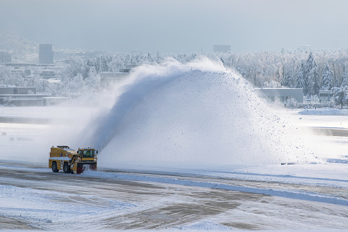 Airport snow blower removing snow from a runway