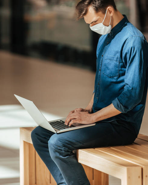 istock close up. ayoung man with a laptop sitting on a bench 1298836827
