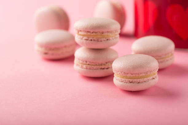 istock Rose macaroons present in festive gift box on pink background, copy space. 1298837924