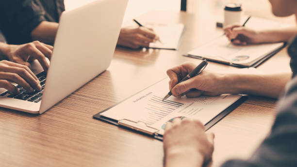 istock group of the employees analyzing financial charts 1298839899