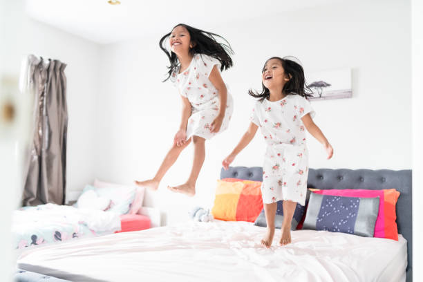 istock Kids jumping on bed having fun. 1298843067