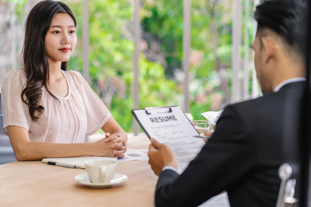 Young Asian woman graduate interviewing with two manager with positive motion in meeting room,Business Hiring new member, Job interview with manager concept stock photo