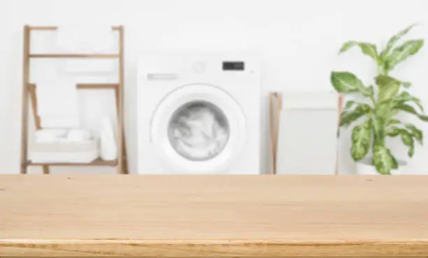 Photo of Empty wooden board over blurred laundry room washing machine background