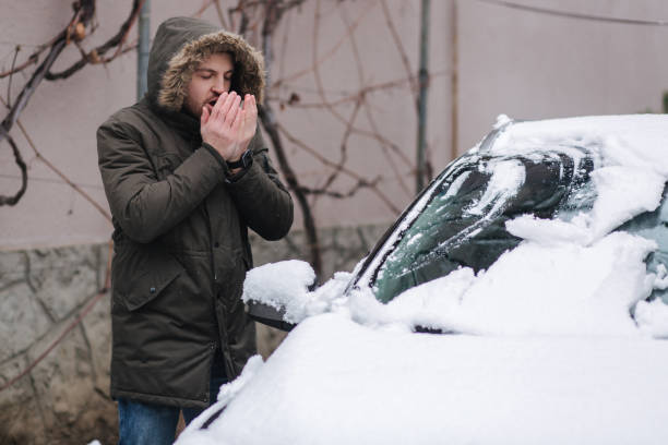 istock Handsome man clean his car from snow using hands. Winter outdoors 1298846582