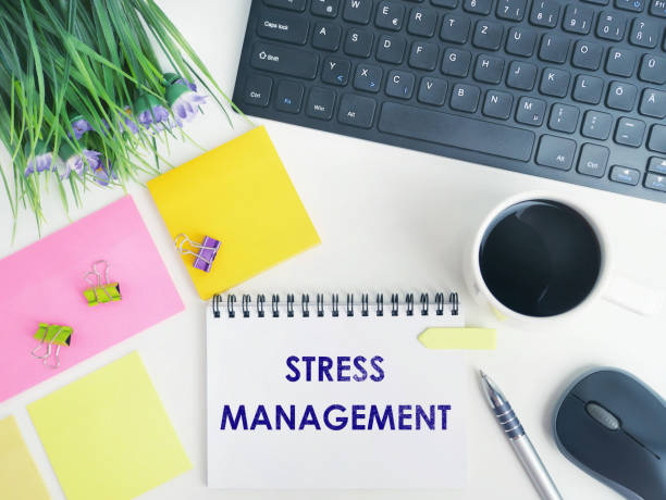 istock Stress Management statement on paper note pad. Office desk with electronic devices and computer. Flat lay composition concept  for blog  or header image of  keep calm. Space for text 1298847906