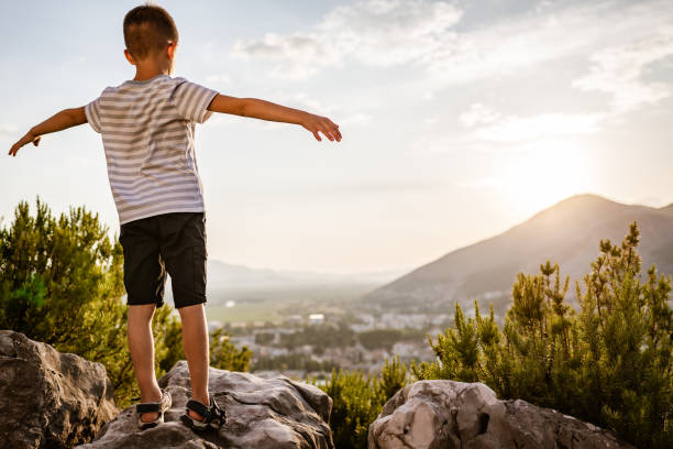 Photo of a little boy looking down on the city of Vienna from a window