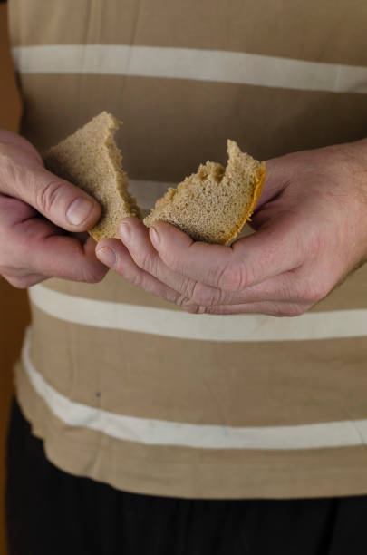 istock A man's hand splits a slice of rye bread in two. 1298850713