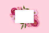 Border frame made of rose and alstroemeria flower on a pink background. Paper sheet mockup.