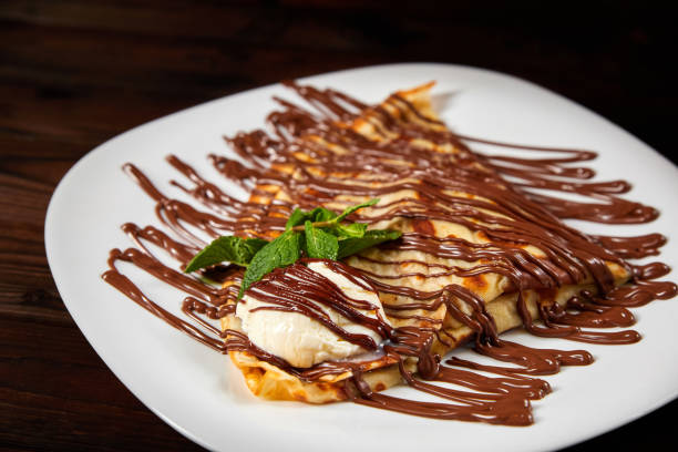 istock Pancake with a scoop of ice cream and chocolate. Close-up, selective focus 1298852016