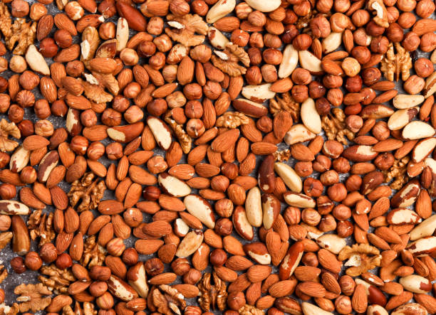 istock Walnuts, almonds, brazilian nuts, hazelnuts mixed together on a dark background 1298854355
