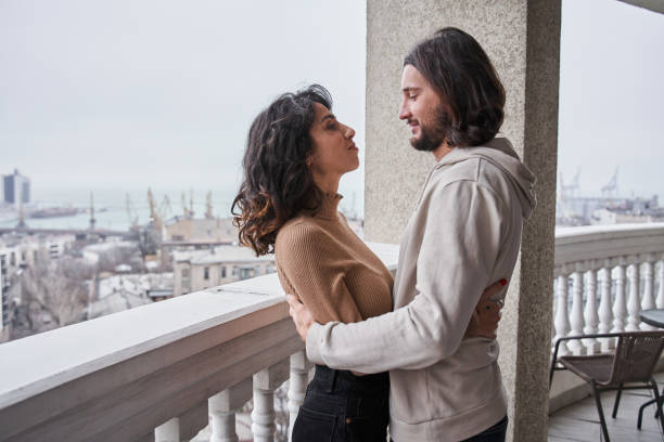 istock Female being embraced by her man at the balcony 1298854598