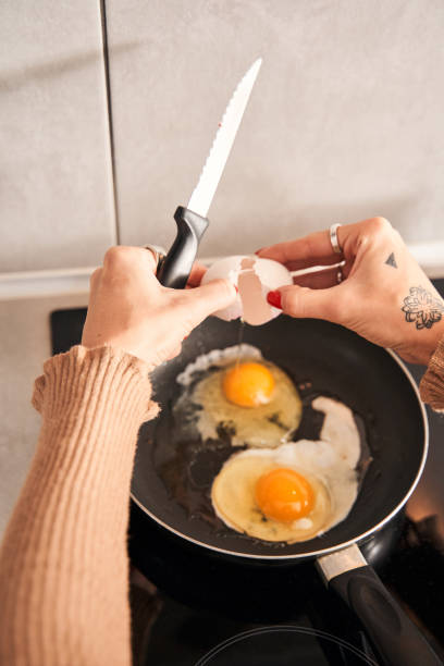 istock Woman preparing scrambled eggs for breakfast in kitchen 1298854695
