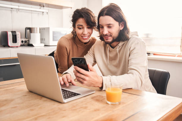 istock Couple sitting at big wooden table in modern kitchen 1298854702
