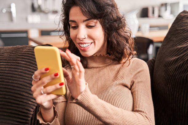 istock Girl checking messages while sitting at the sofa 1298854764
