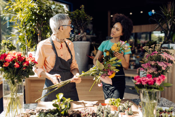istock Two florists arranging fresh plants at their flower store 1298856103