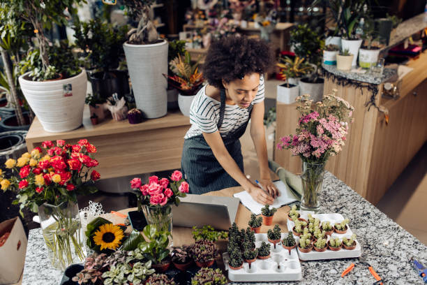 istock Young florist planning business at her store 1298856146
