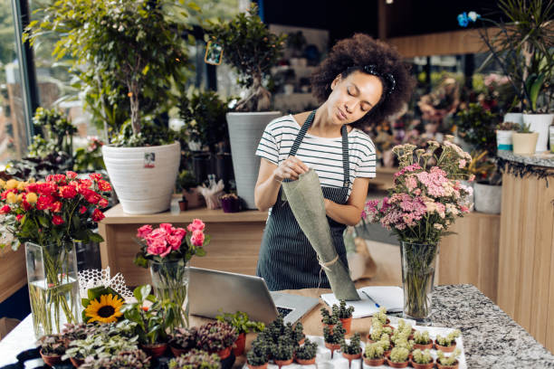 istock Young florist working at her store and enjoying 1298856151