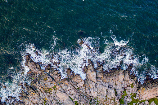 Bornholm, Denmark - August 10, 2020: Top down drone view of the rocky cliff coastline close Hammerknuden