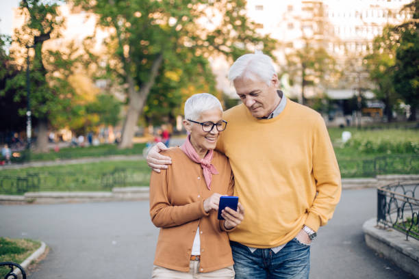 istock Happy senior couple using a smartphone during their walk through the city 1298856427