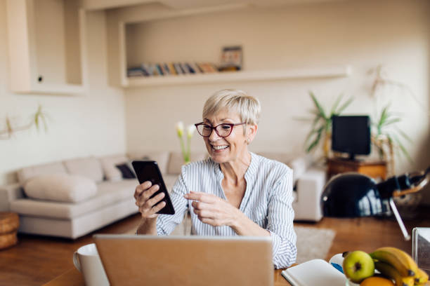 istock Mature businesswoman taking a break and using her smartphone 1298856861